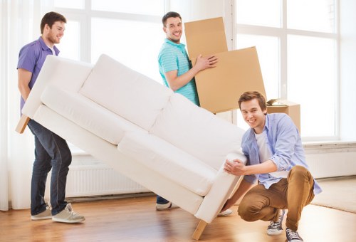 Professional piano movers using protective equipment and padding